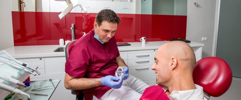 Д-р Стоян Деков показывает элайнер пациенту в Deckoff Dental